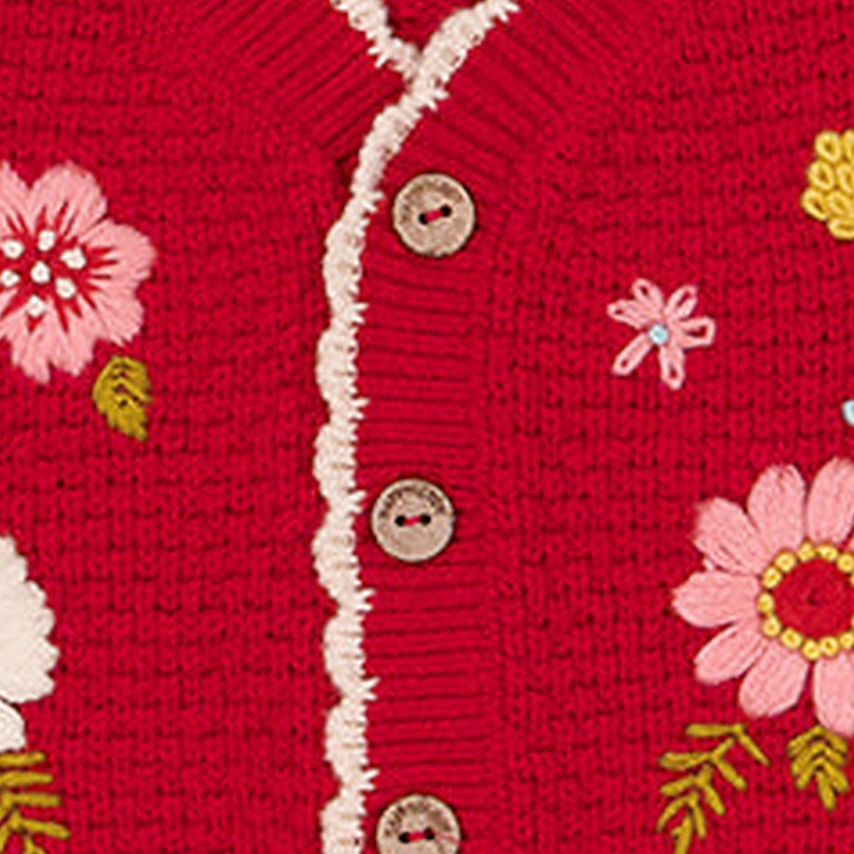 Close detail of hand embroidered flowers on a Happyology knitted vest